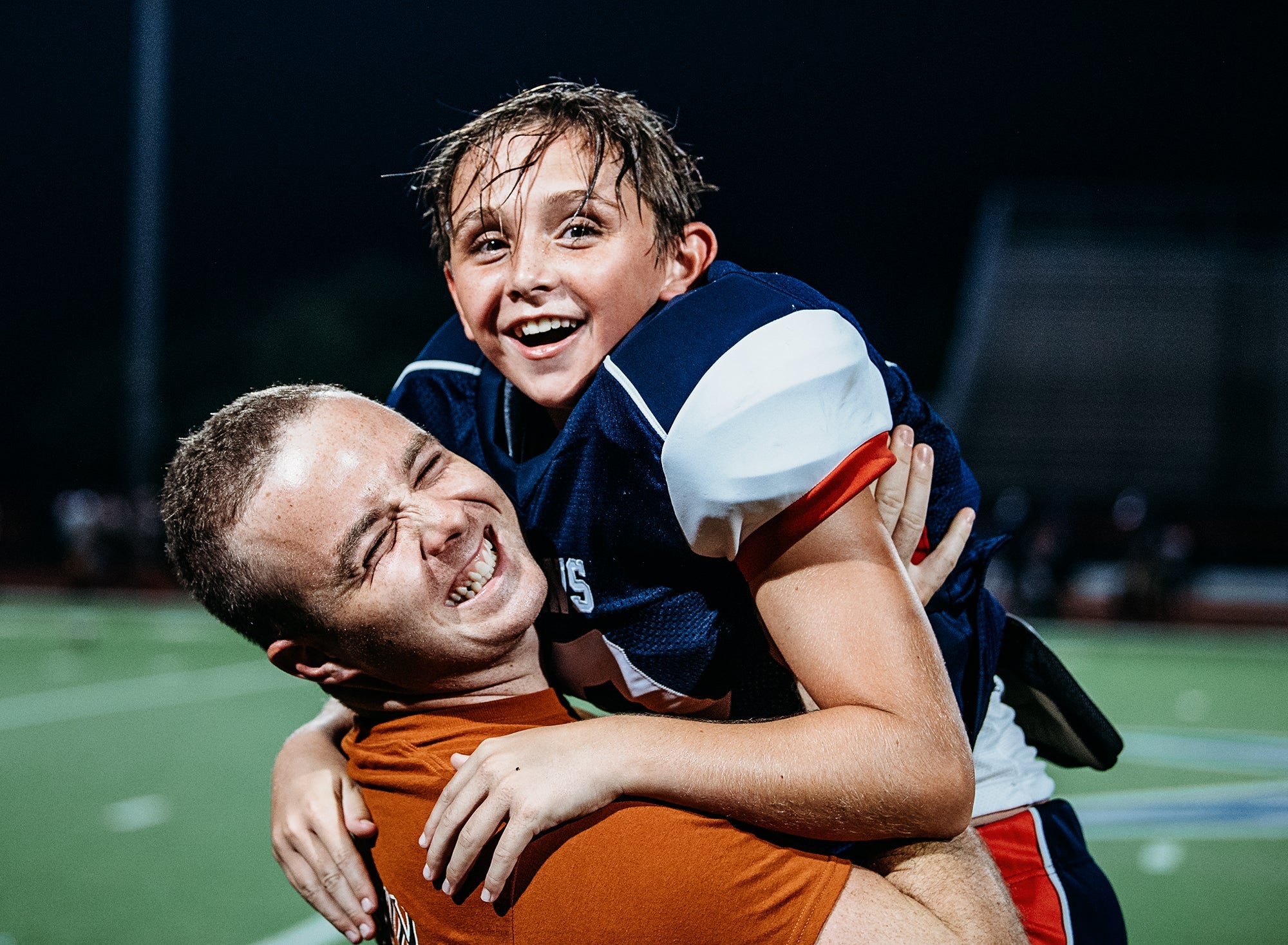 Two young men embracing after a football game