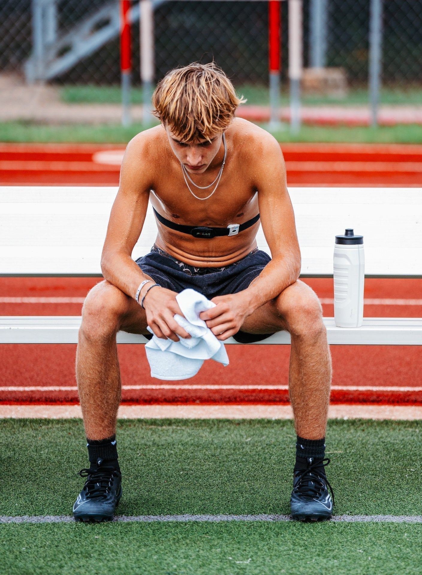 High school athlete sweating with a cool rag in the high temperature of summer heat