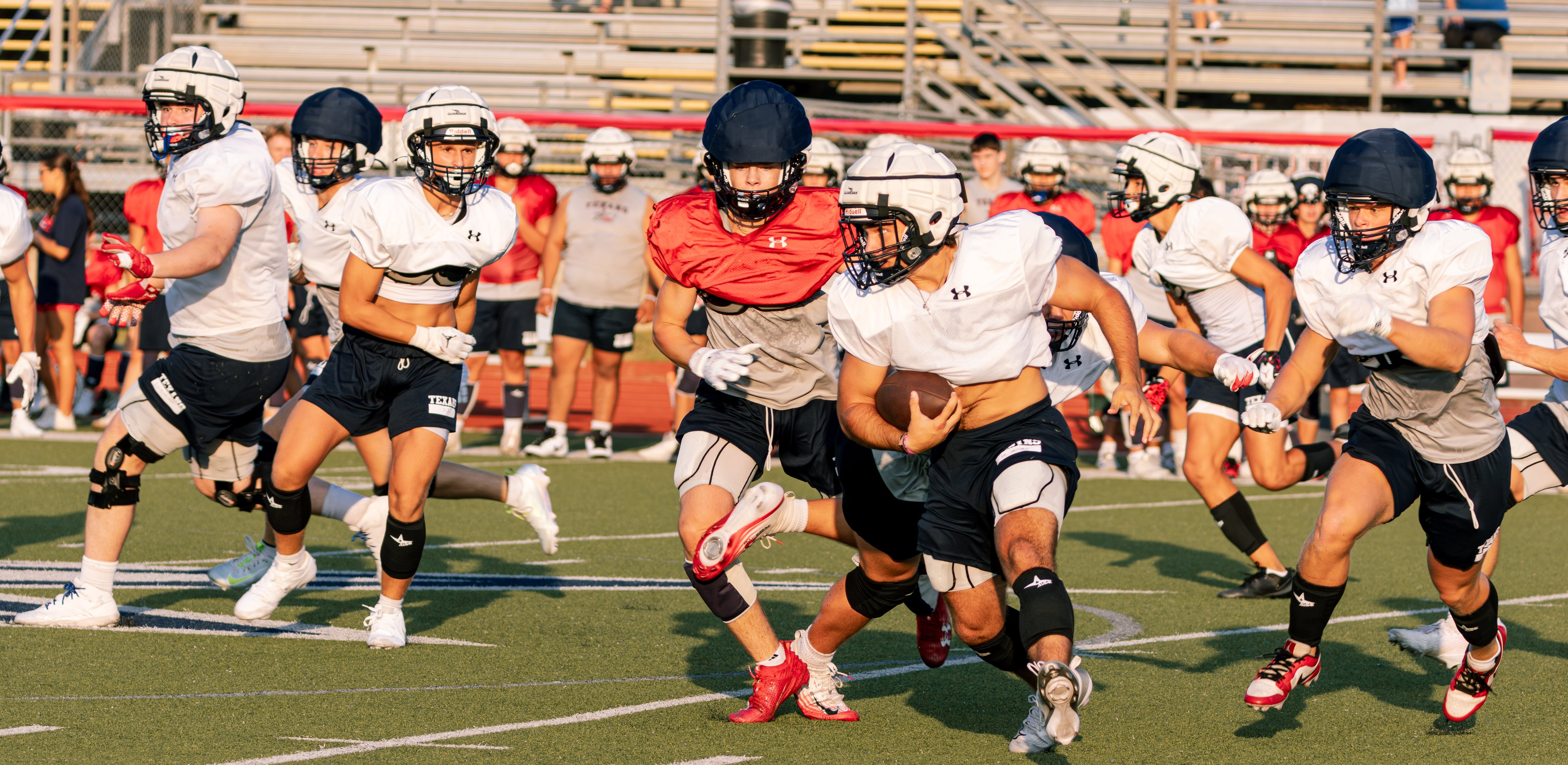 High school football team scrimmaging in the summer heat
