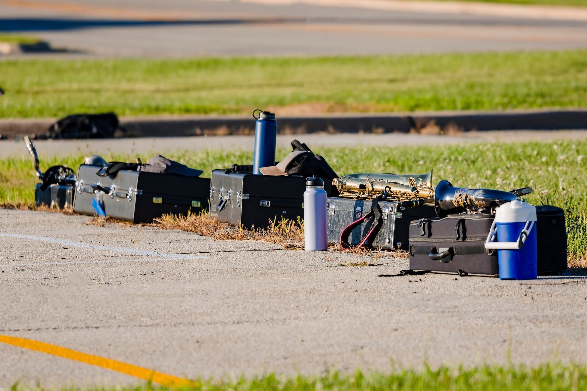 High school band members musical instruments and water bottles during band camp