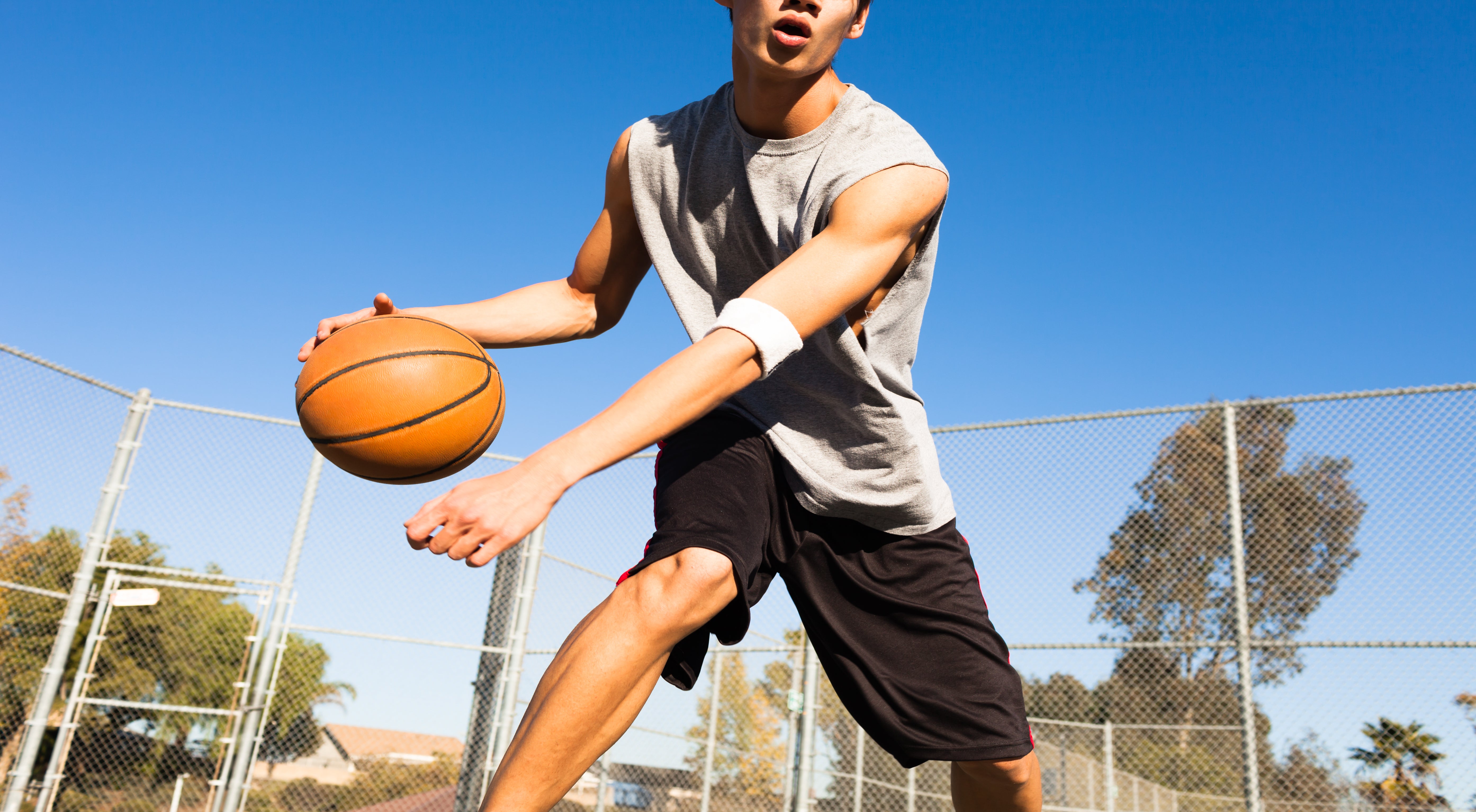 Basketball player dribbling the ball on a hot day