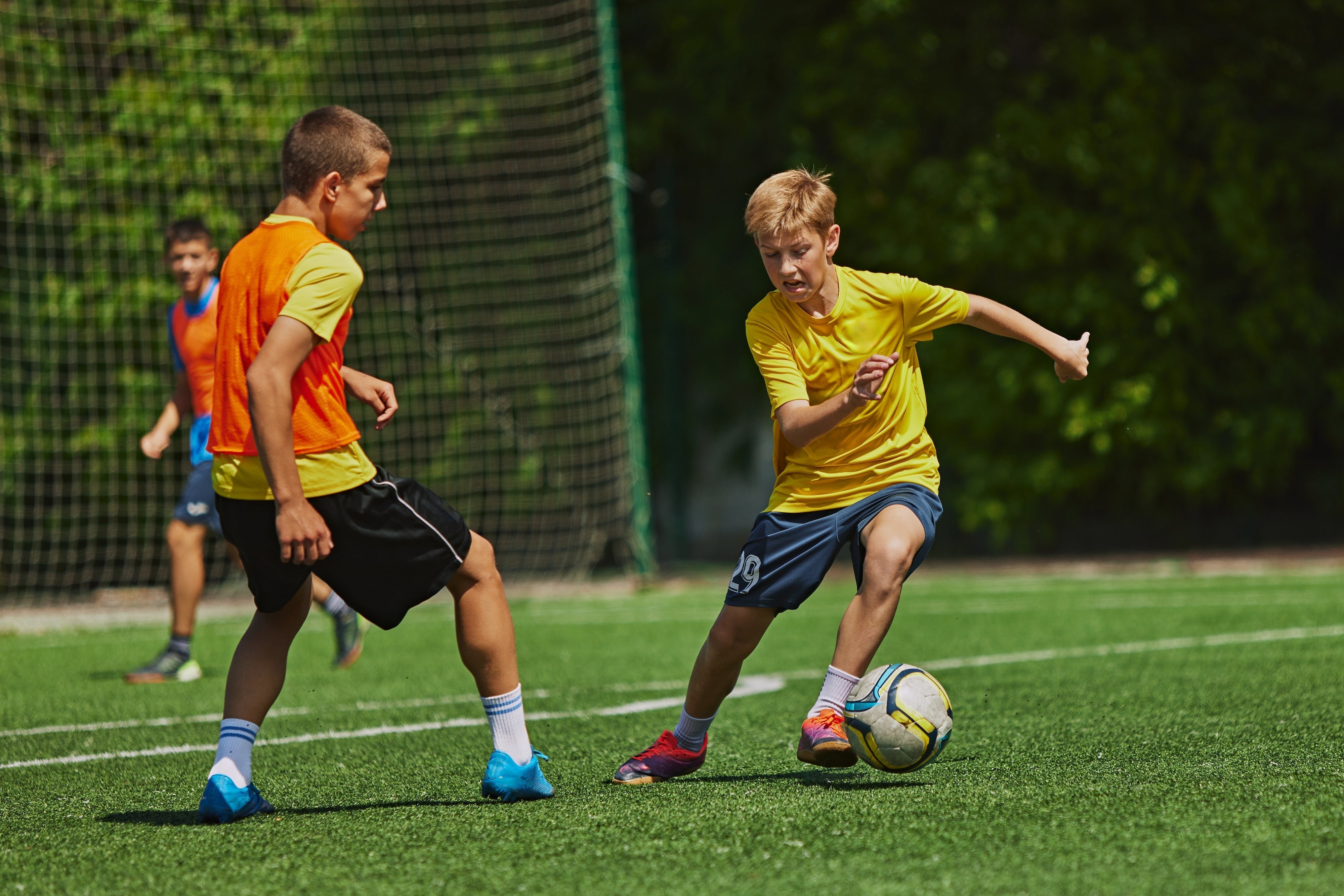 Youth soccer players kicking and defending the ball