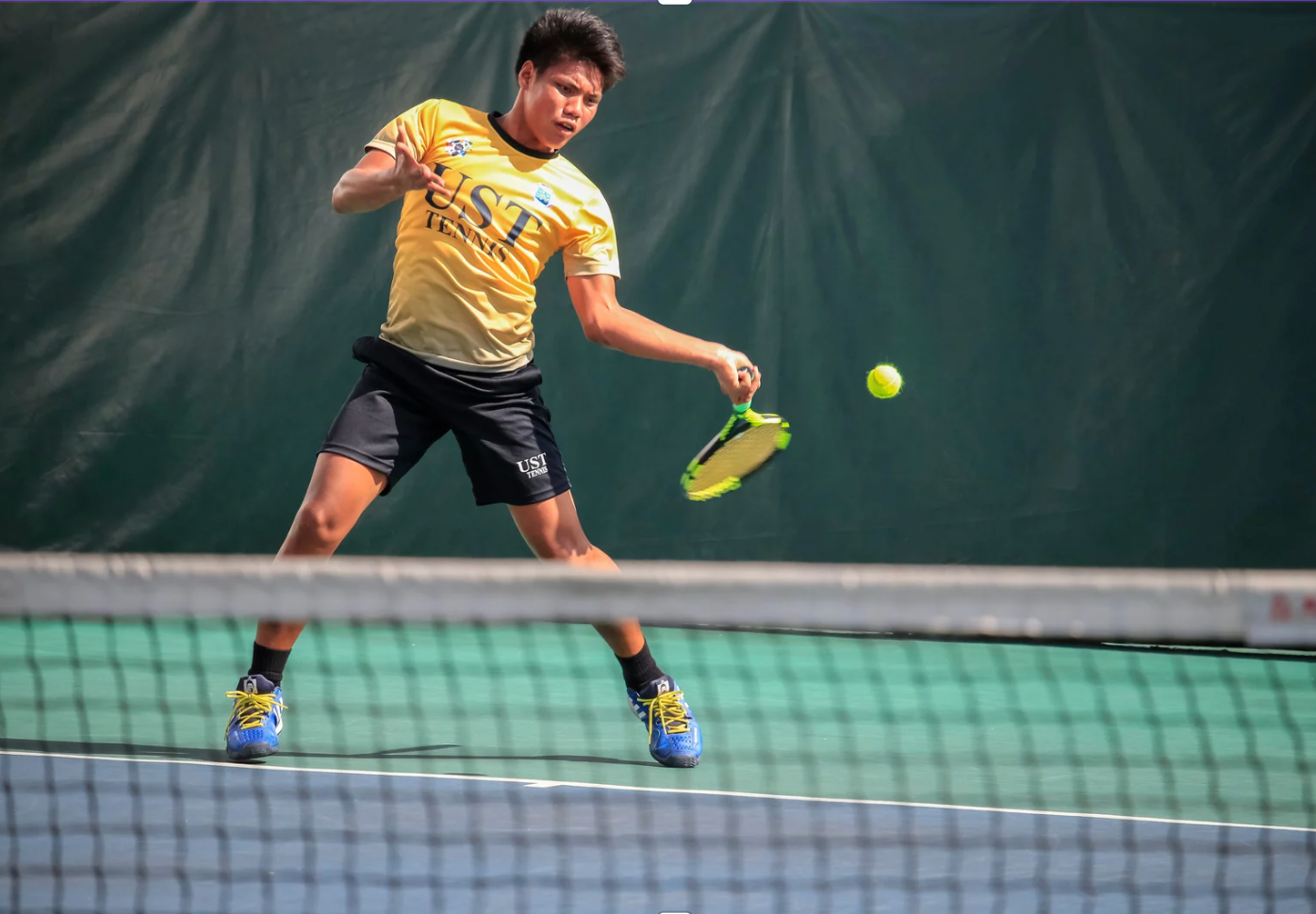 Sweaty youth tennis player hitting the ball